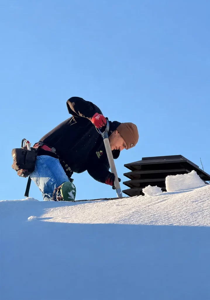 Roof technician working on snow-covered roof in Ottawa winter demonstrating durability in Canadian climate