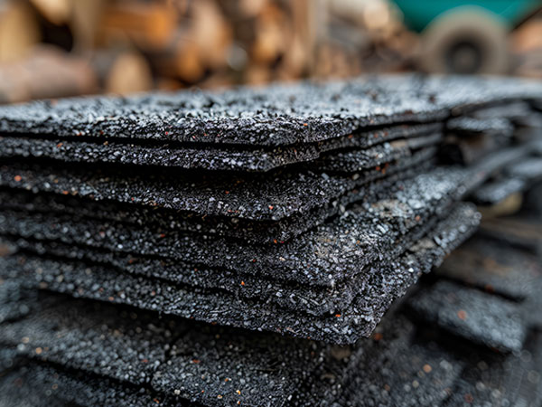 Stacked black asphalt shingles ready for roofing
